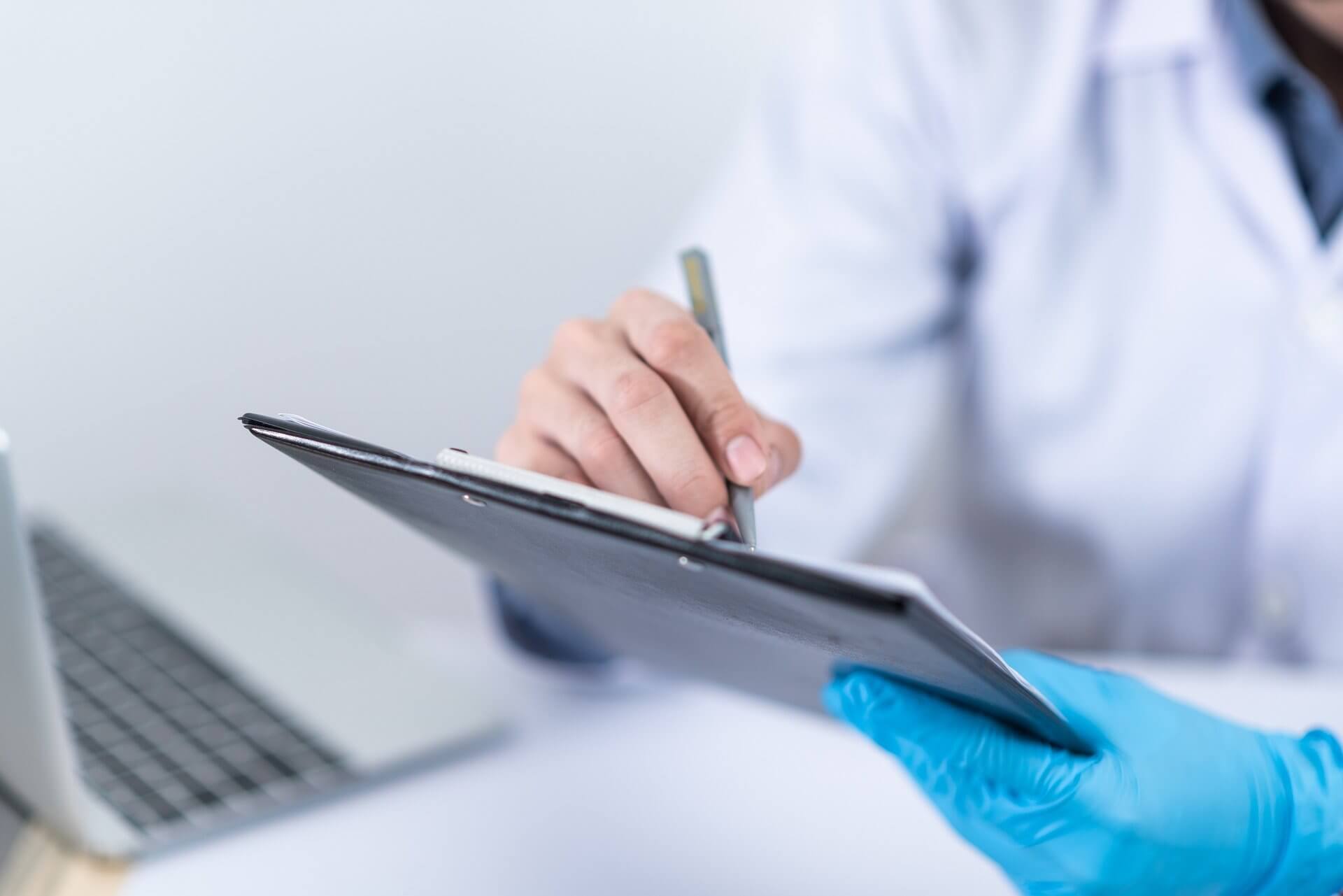 Doctor writing on a clipboard.