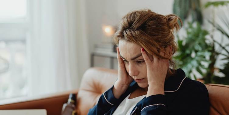 A person holding her head

AI-generated content may be incorrect.